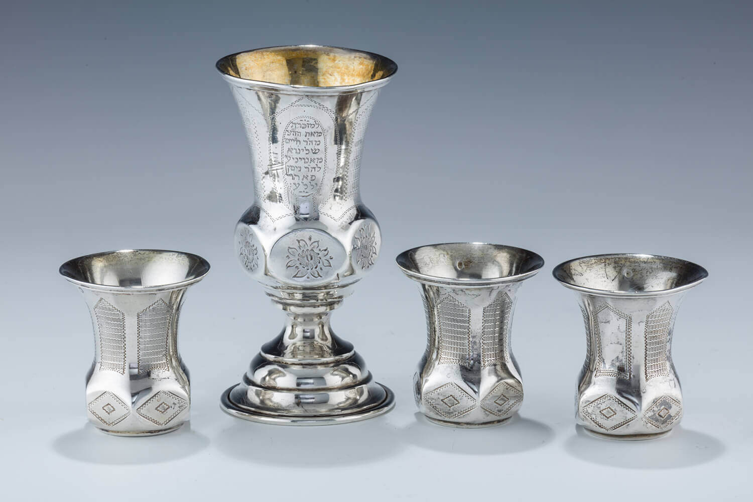 064. A SILVER KIDDUSH GOBLET WITH THREE MATCHING CUPS