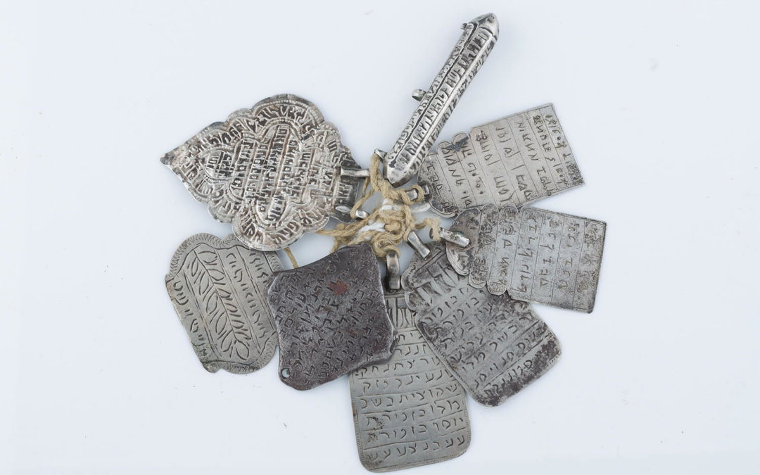 027. A GROUP OF EIGHT SILVER AMULETS