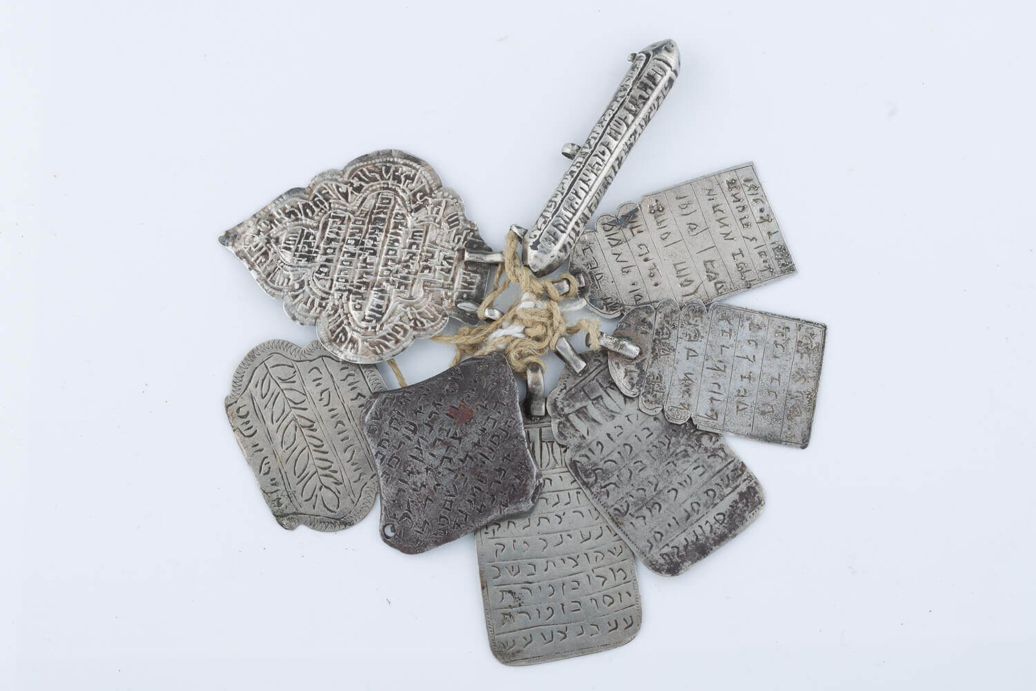 027. A GROUP OF EIGHT SILVER AMULETS