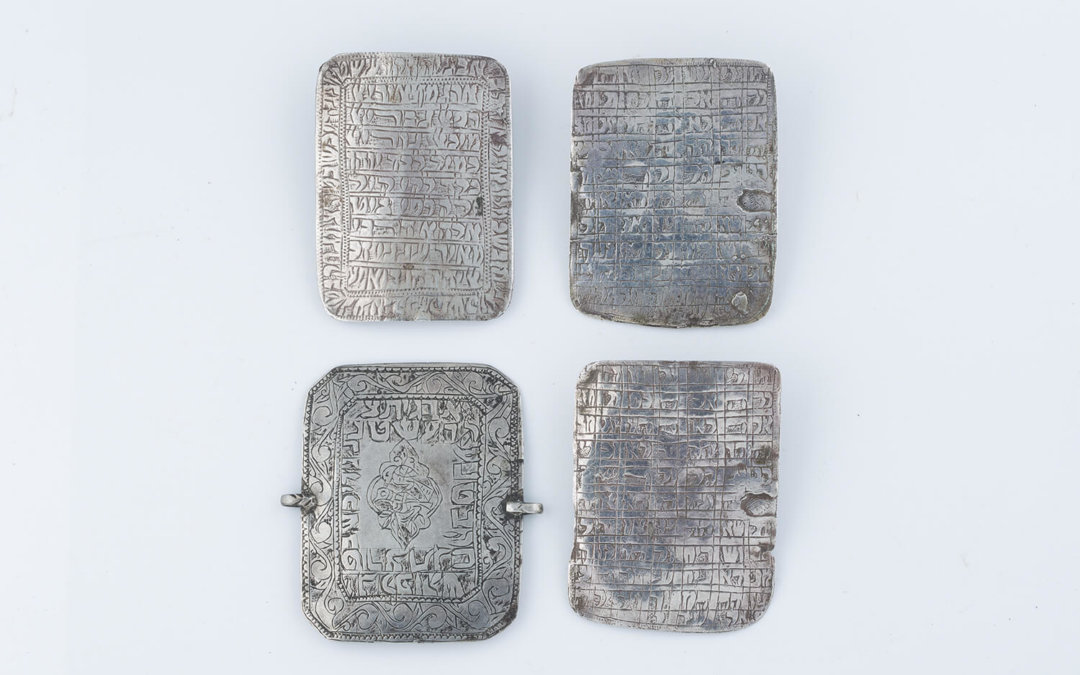 028. A GROUP OF FOUR SILVER SQUARE AMULETS